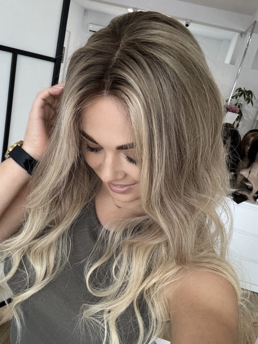 Peruka Daisy 55 cm z naturalnych włosów w kolorze ciepły blond ombre, założona na głowie, z przedziałkiem ustawionym na środku, lace front i realistyczną linią włosów.